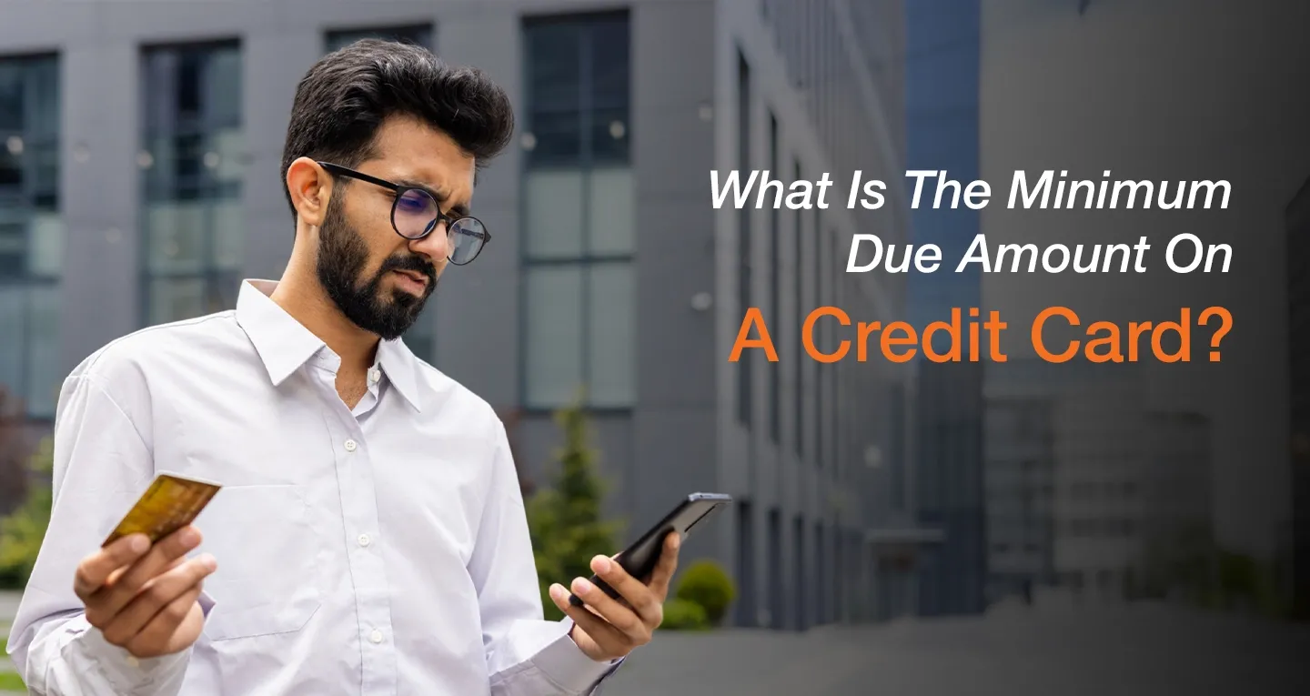 Man checking credit card minimum due amount on phone while holding card outdoors